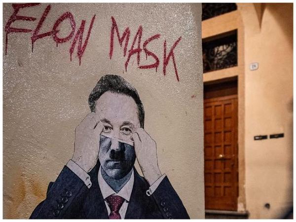 Foto: Hitler mit Musk Maske, kein Banksy, auch wenn es im Stil des weltberühmten Graffiti Streetart Künstlers gesprüht wurde. Elon Musk/Mask nimmt Maske ab. Elon Musk gründete Tesla - Adolf Hitler gründete Volkswagen - Musk will zum Mars - Hitler wollte die Welt