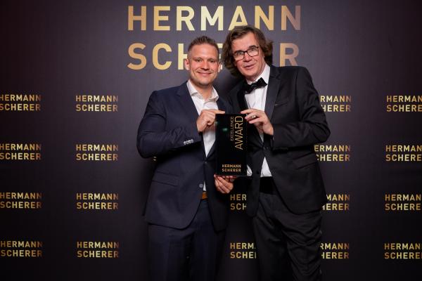 Veranstalter Hermann Scherer übergibt KI- und Datenschutz-Experte Marc Pastuska den Excellence Award Mit Rede zu KI: Datenschützer holt Excellence Award