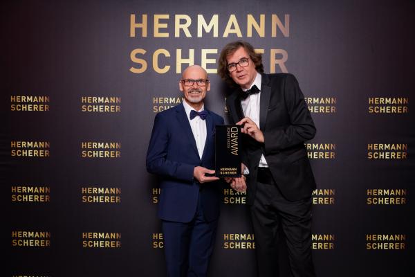 Beim Speaker Slam nahm Jürgen Müller den Excellence Award aus den Händen von Juror Hermann Scherer e Jürgen Müller gewinnt Internationalen Speaker Slam Award