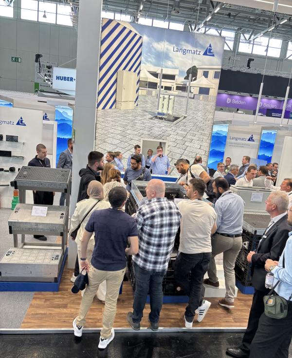 Die Besucher am Messestand von Langmatz zeigen großes Interesse am Gf-Netzverteiler EK881. ANGA COM 2025: Langmatz begeistert mit Innovationen und zukunftssicheren Lösungen